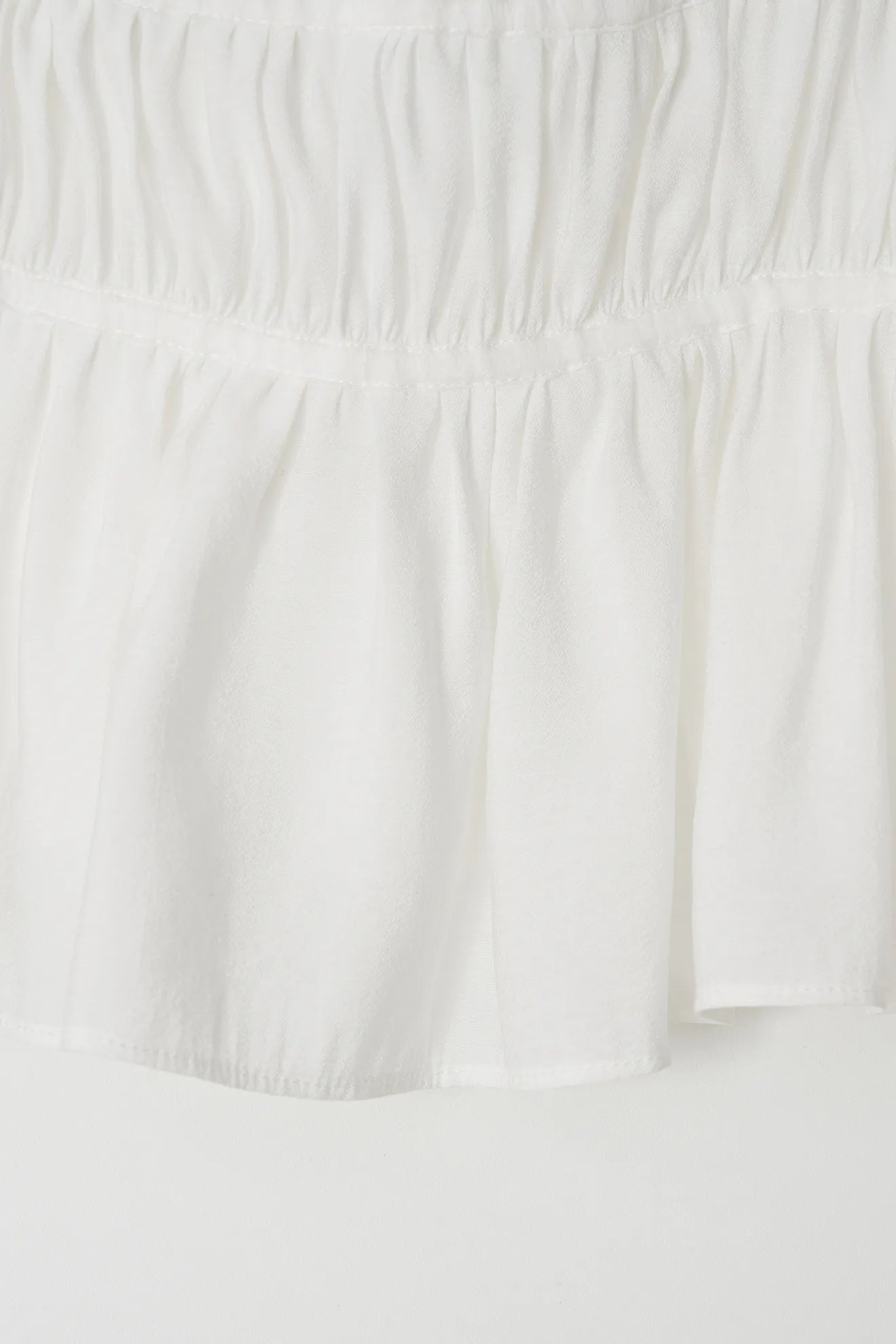 Pleated hem detail of Atelier Edition Shirring String Pleated Top White