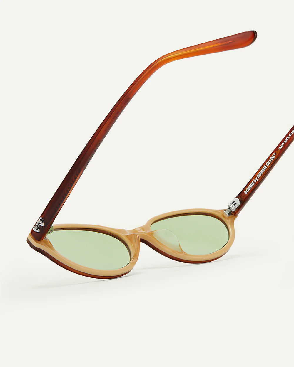 Detail of Bonnie Clyde baby sunglasses layered brown frame with green tinted lenses