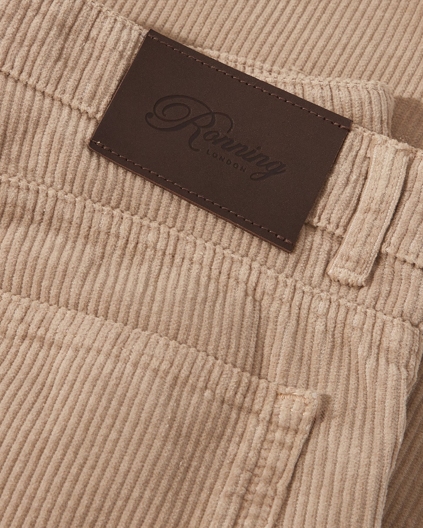 Brown corduroy jeans fabric and leather patch detail