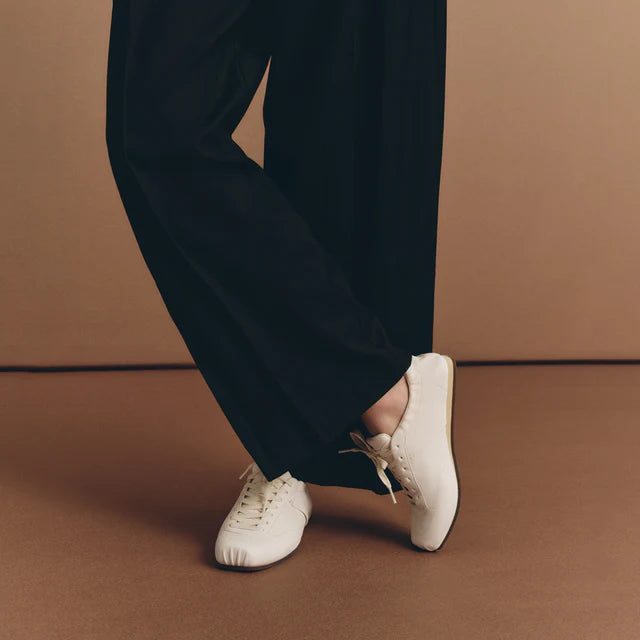 Model wearing Foot Industry Ballet Training White leather sneakers in motion