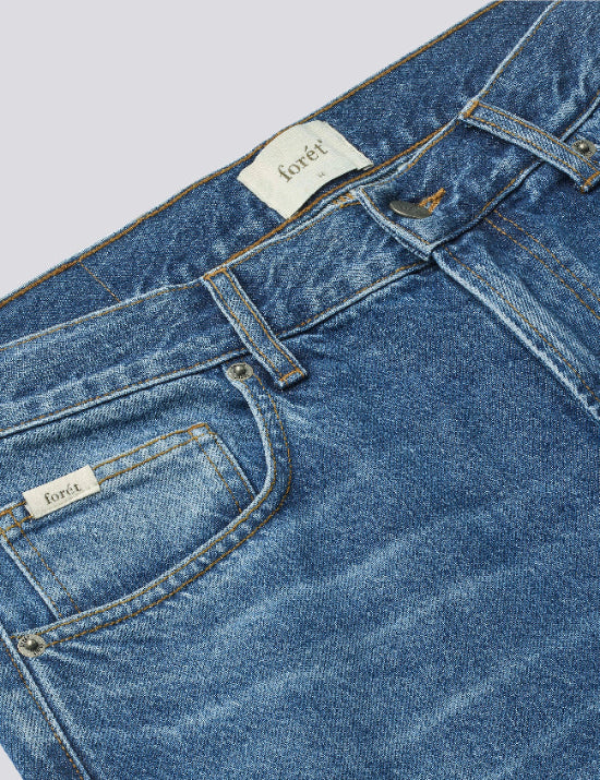 Close-up denim texture detail of Foret Heath regular fit jeans washed mid blue