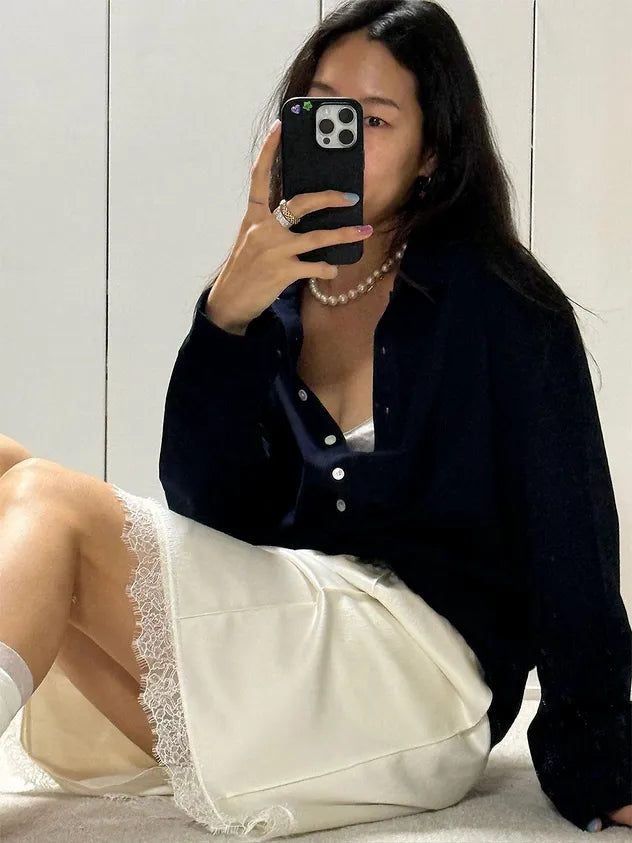 Model wearing FRITUR Pintuck Satin Midi Skirt in White in a mirror selfie