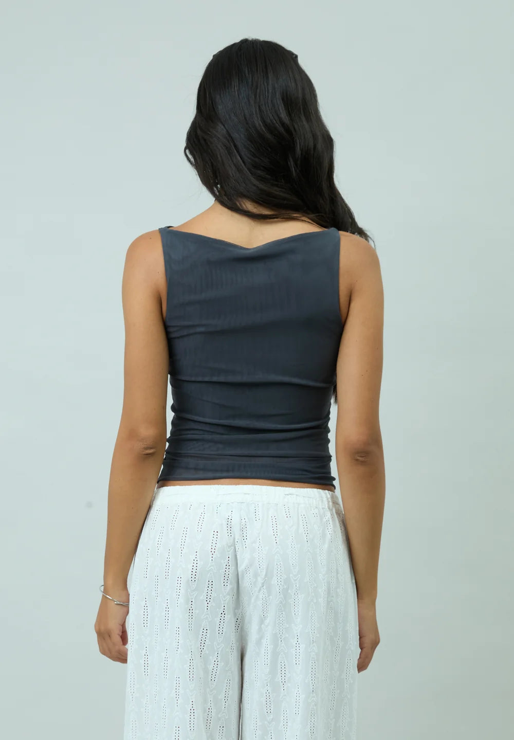 Back view of model wearing House of Sunny Double Layer Sleeveless Mesh Top in Steel Grey