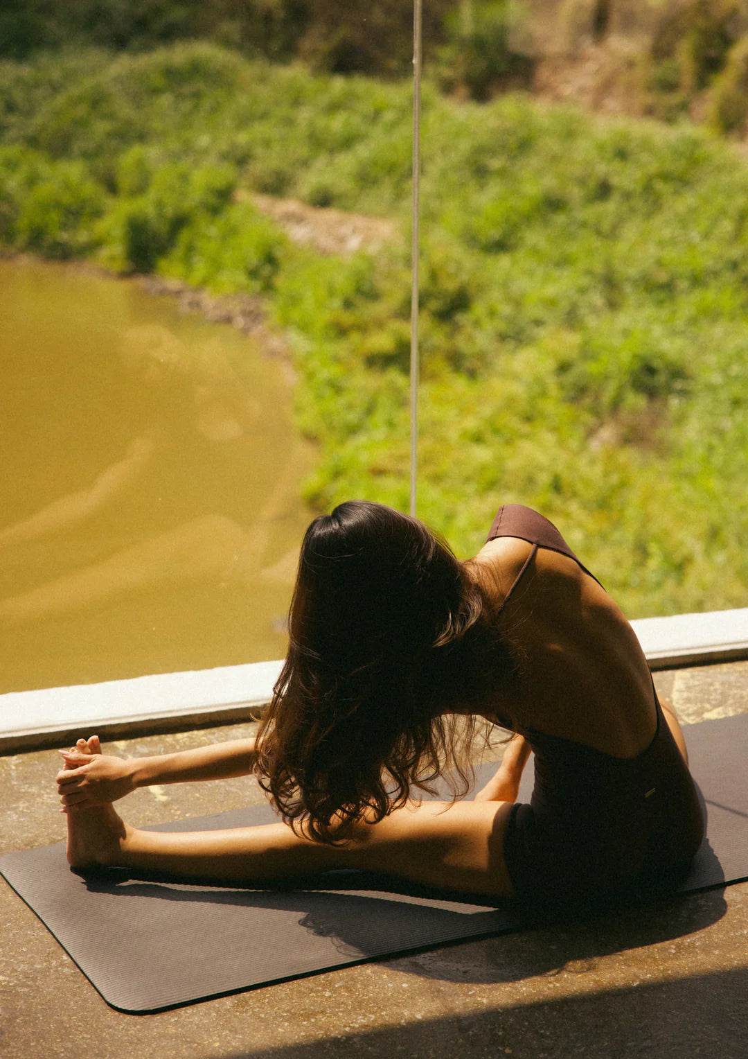 Kamari Backless Onesie WearRame Bali brown yoga stretch pose
