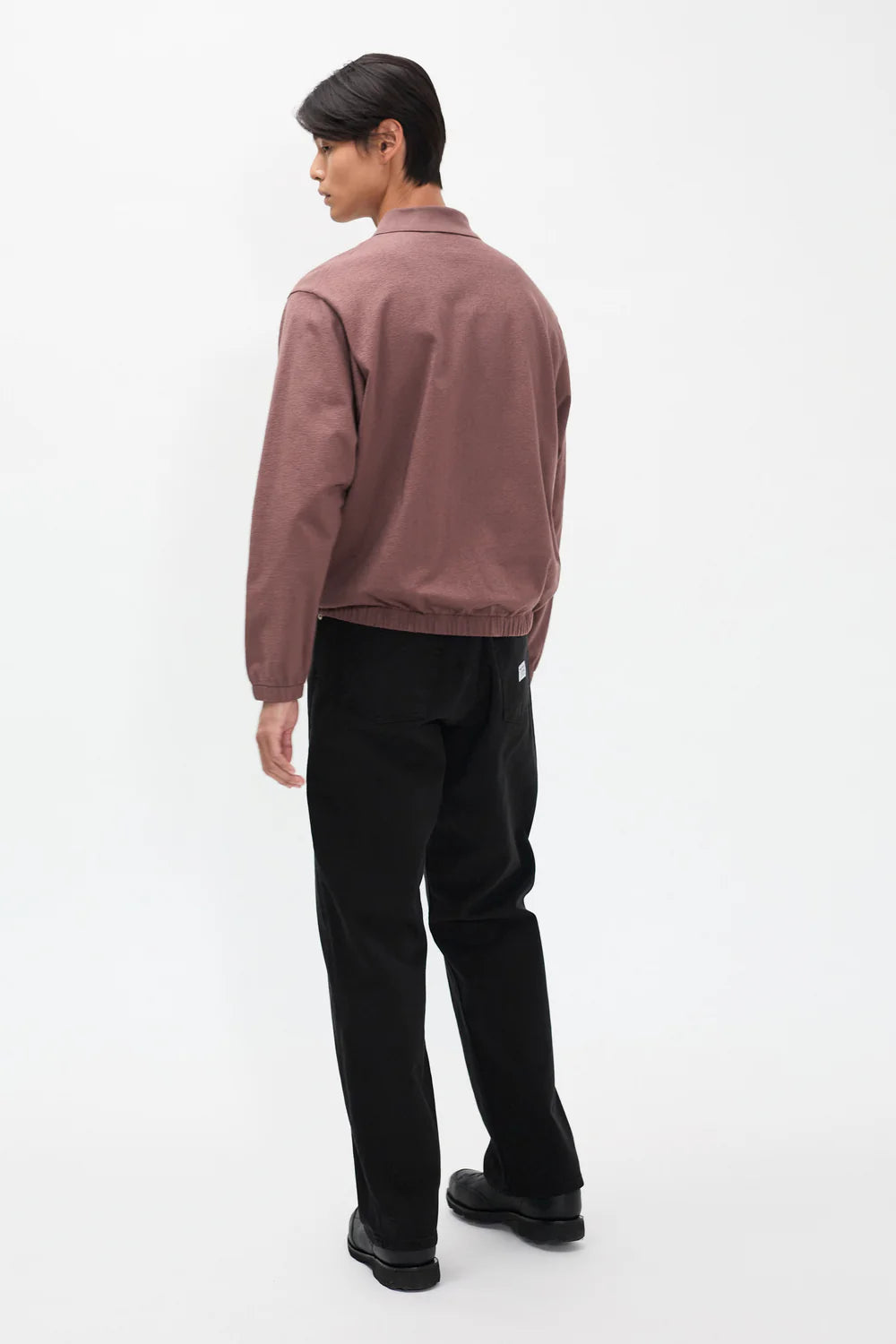 Model wearing Norse Projects Korshavn black relaxed fit twill pants
