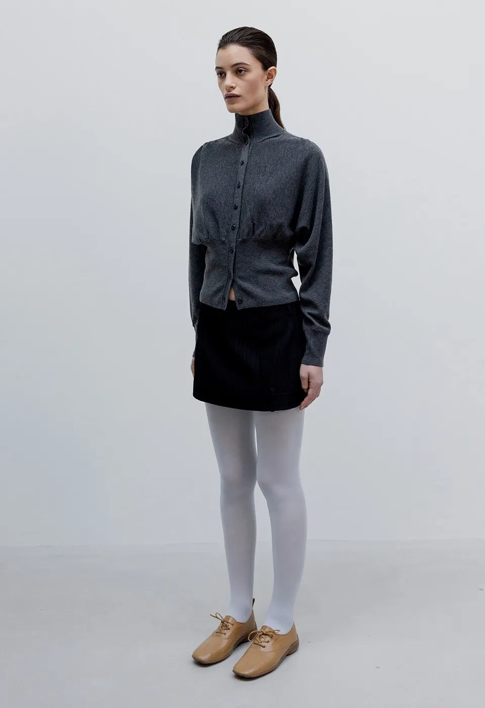 Side view of OPENYY Knitted Button Up Blouson Cardigan in Charcoal Black worn