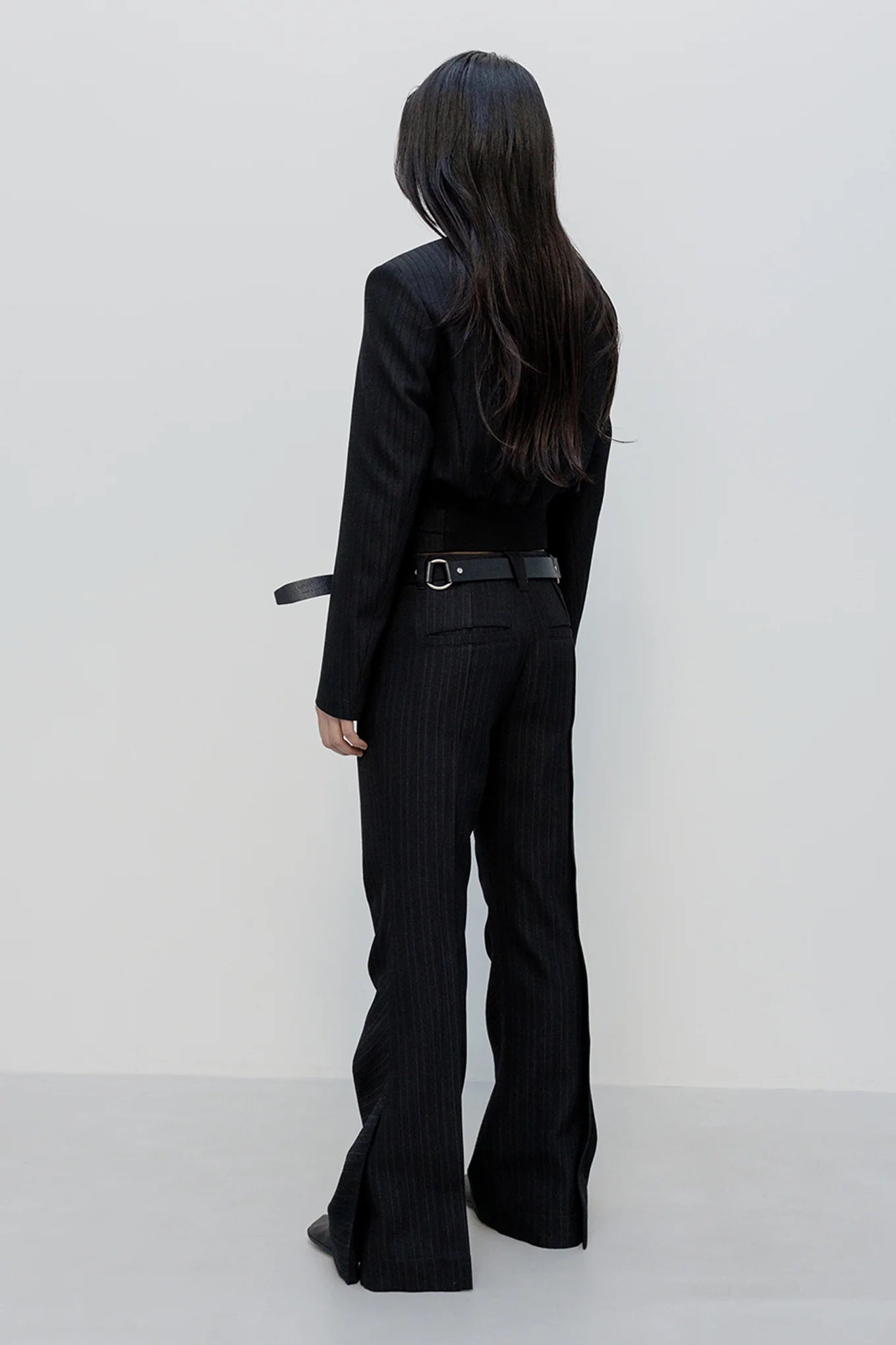 Back view of OPENYY Stripe Tailored Bootcut Pants in Black worn