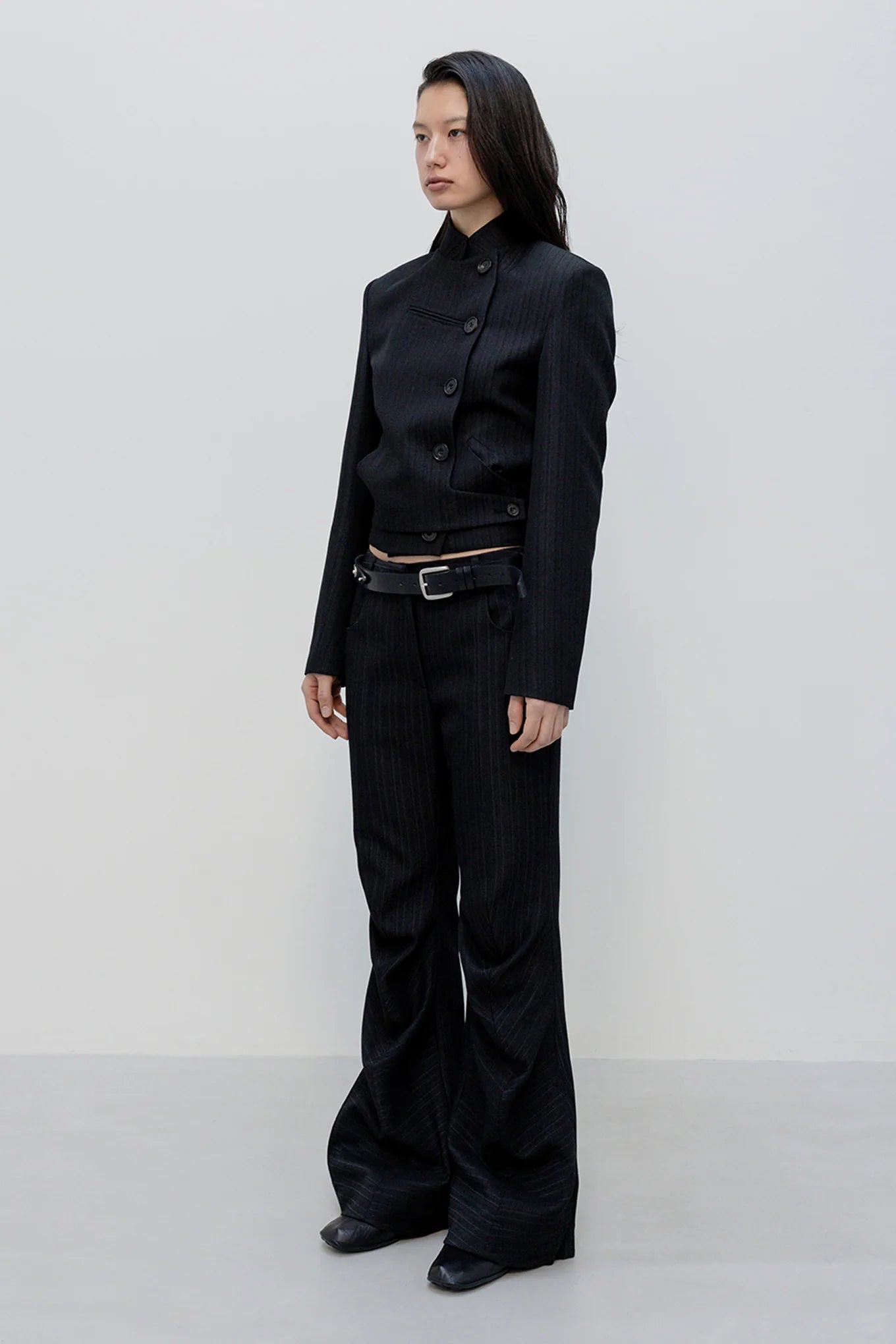 Side view of OPENYY Stripe Tailored Bootcut Pants in Black worn