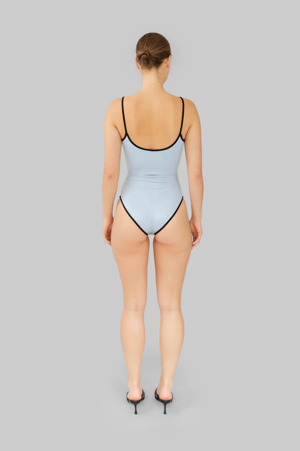 Model wearing OperaSPORT Luz Swimsuit Baby Blue back view