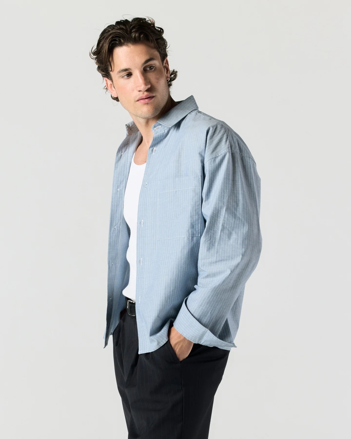 Side angle of model wearing RONNING Everyday Shirt in Blue Stripe
