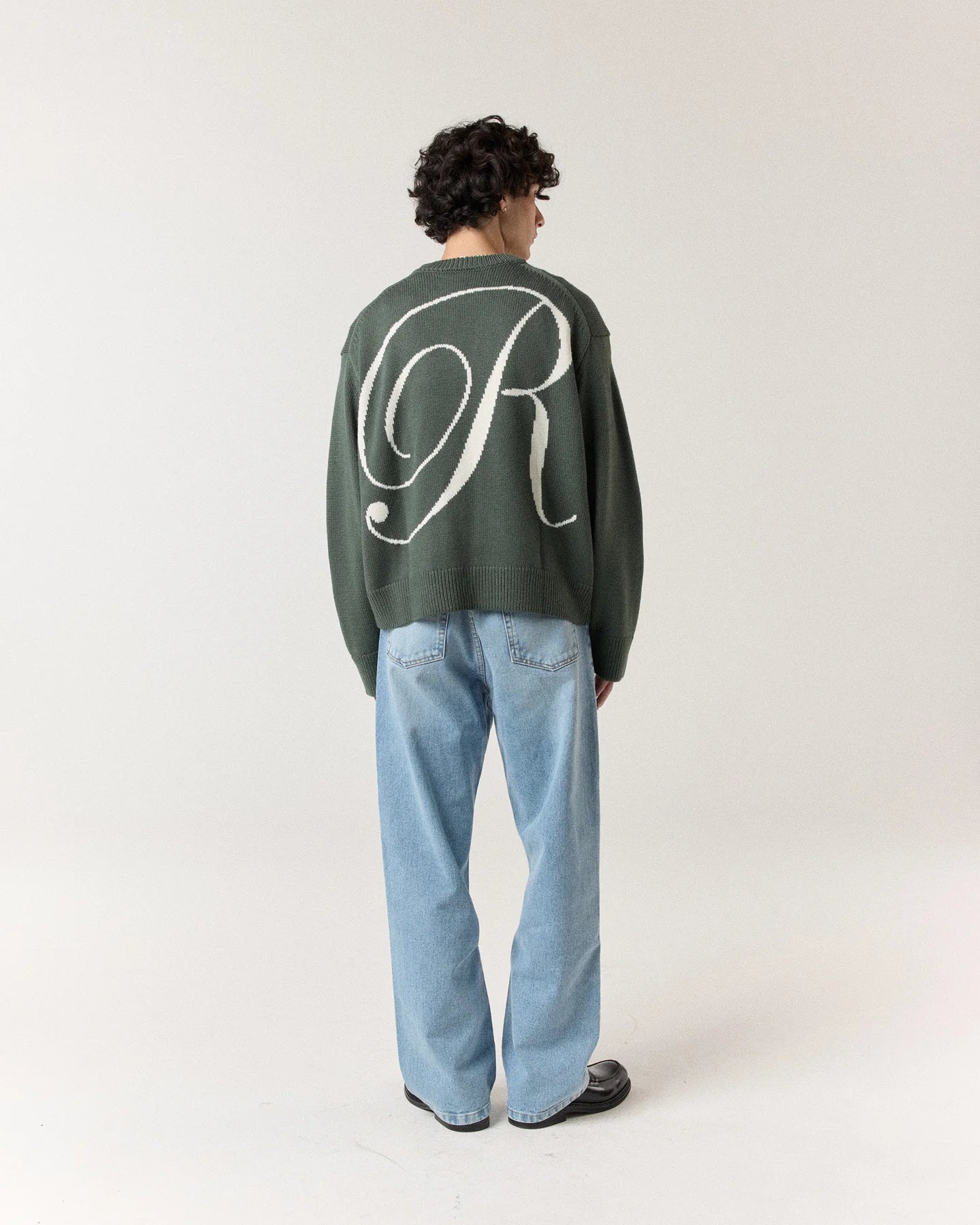 Back view of model wearing RONNING R Knit Sweater in Green