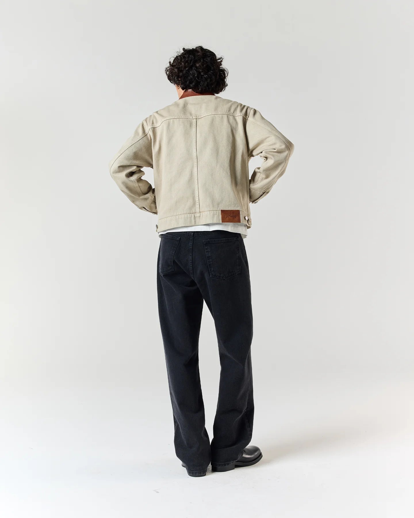 Back view of model wearing RONNING Utility Fireman Jacket in Washed Sand