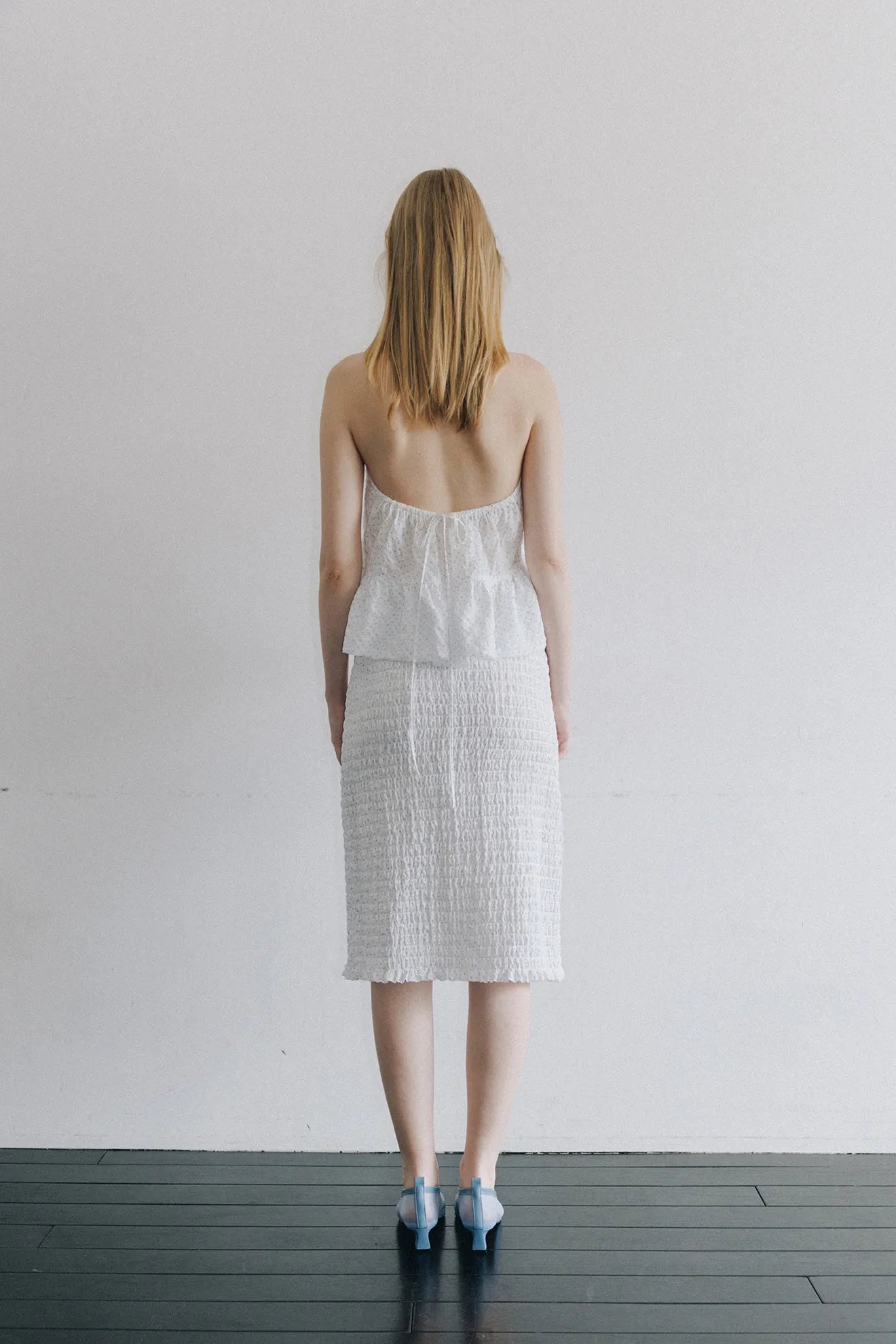 Back view of model wearing Smocked Banding Skirt in White