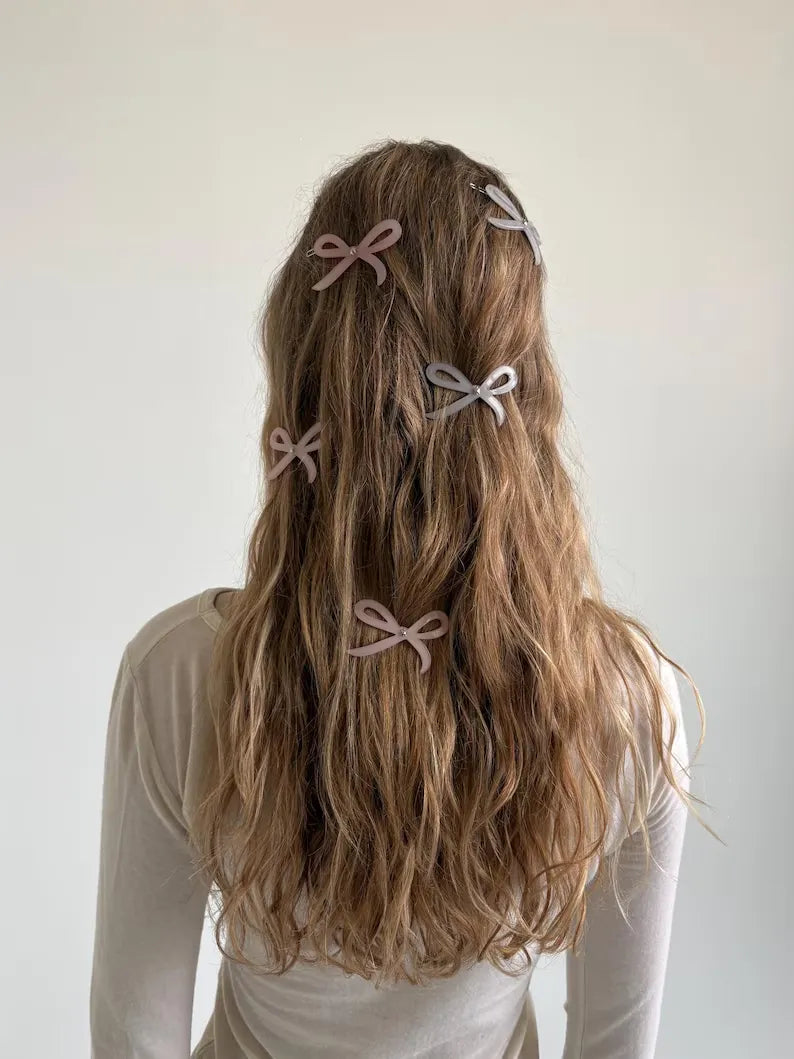 Model wearing Turtle Story Ribbon Side Clips in Soft Pink