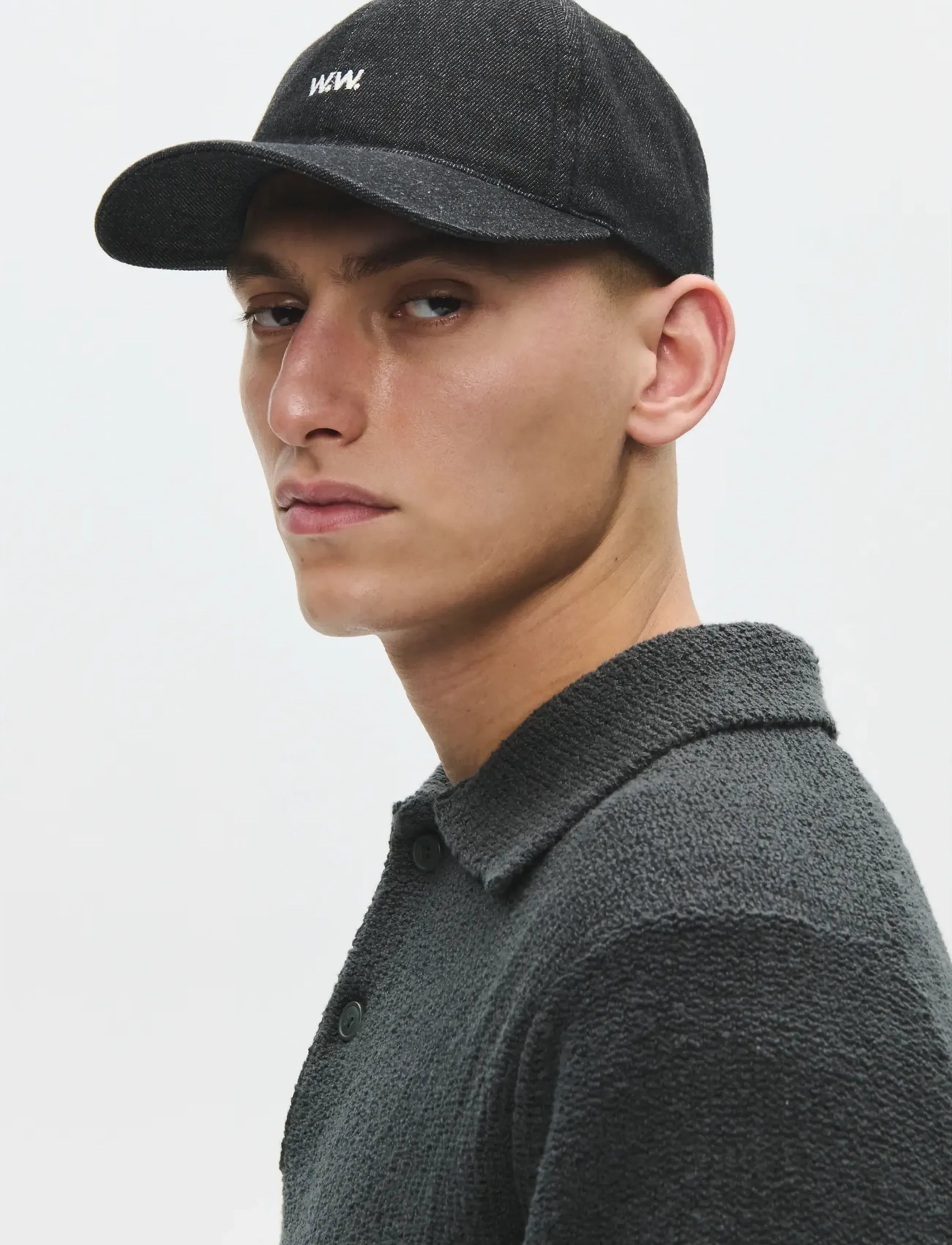 Side view of model wearing Wood Wood W.W. Cap in Black Sand