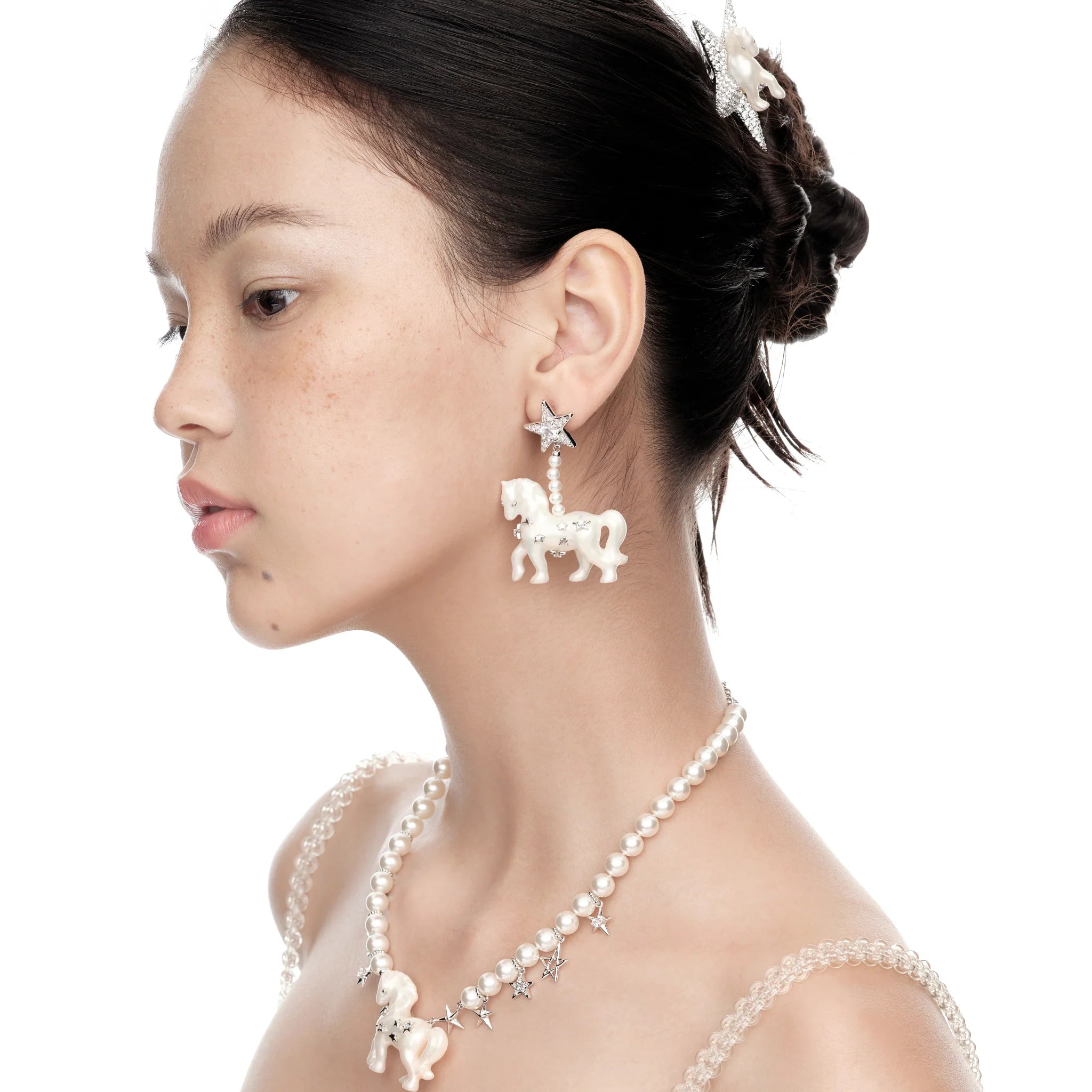 Model wearing YVMIN Paradise Pony Star Earrings in White